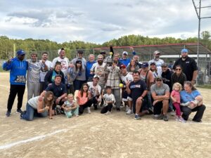 Group celebrating victory on softball field.