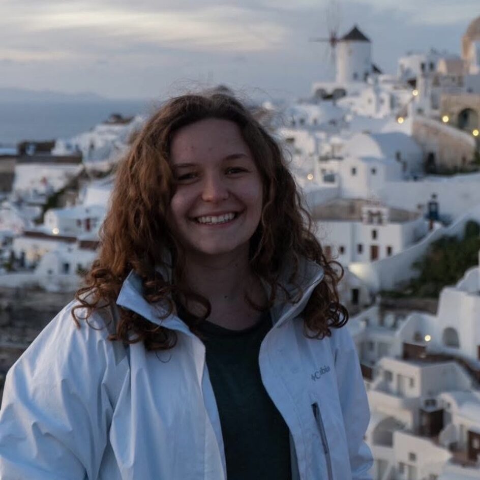 Person smiling in Santorini landscape.